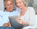 Senior couple surfing on internet with electronic tablet