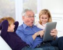 Grandfather with kids using electronic tab